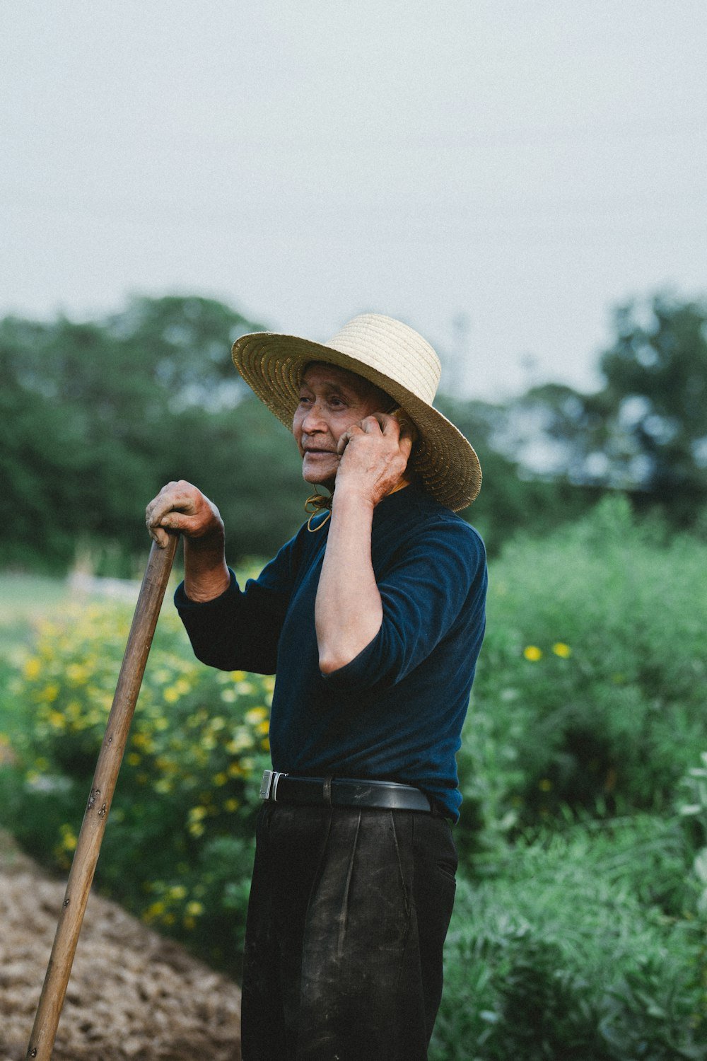 A farmer talking on the phone in his field